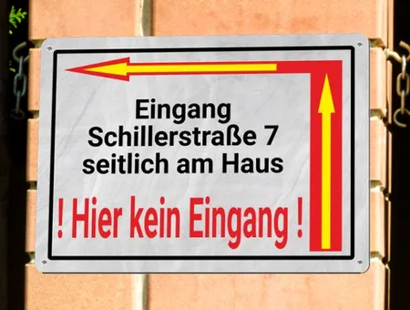 Wegweiser Eingang um die Ecke Bild