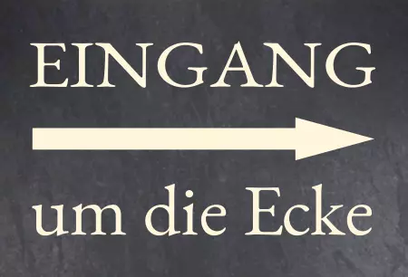 Wegweiser Eingang um die Ecke Bild